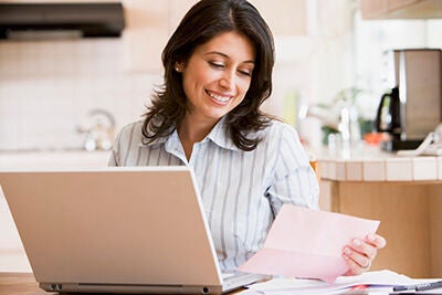 Woman looking at a computer managing her monthly budget