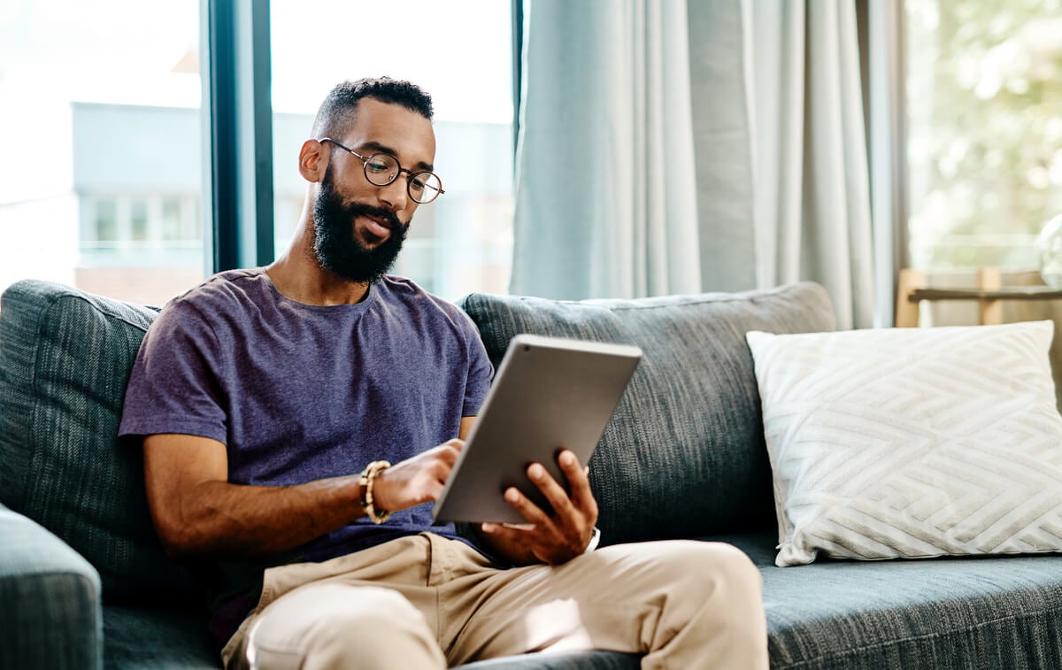 Man reading about Unemployment Benefits on his tablet.