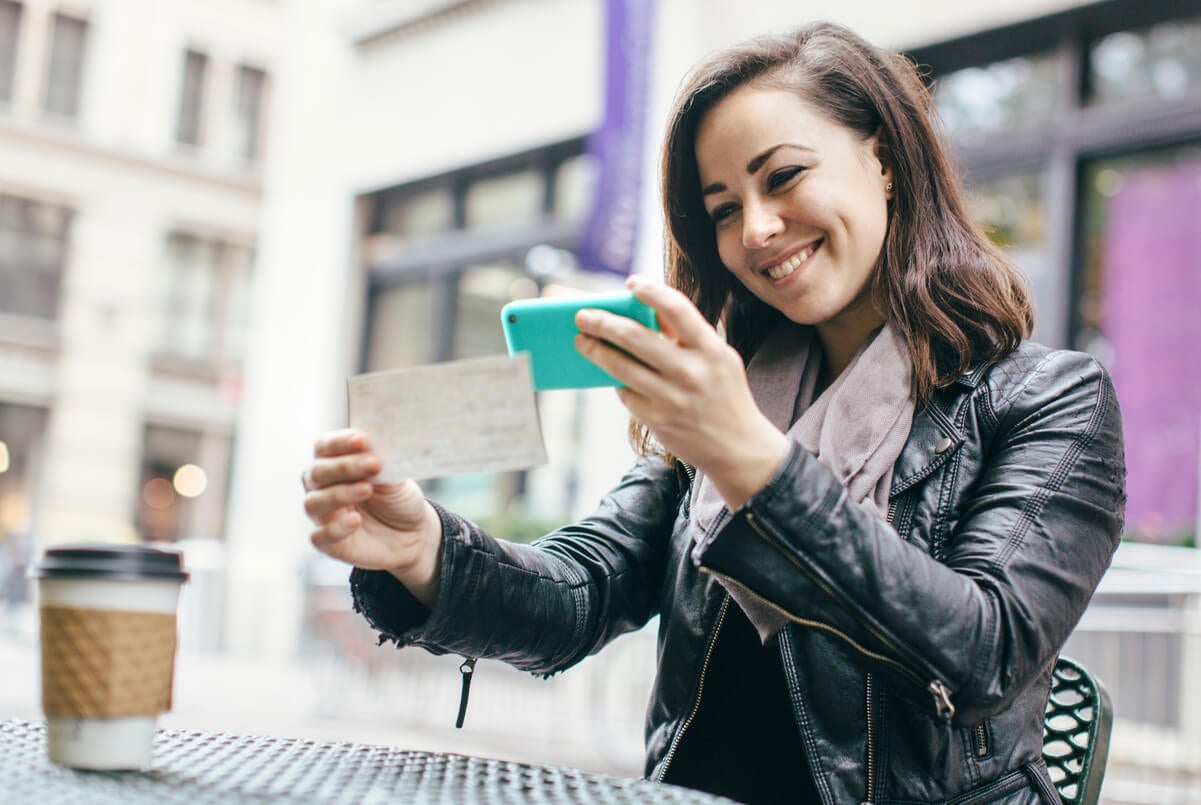 Woman depositing her check on her mobile phone